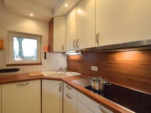 a kitchen with white cabinets and a sink at Cozy Holiday Home in Robertville with Sauna in Robertville