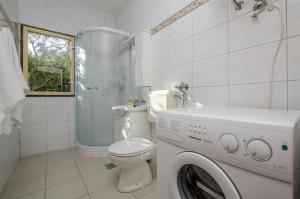 a bathroom with a toilet and a washing machine at Apartments Mate in Maslinica