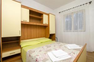 a small bedroom with a bed and a window at Apartments Mate in Maslinica