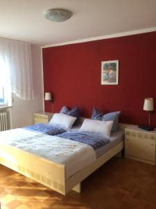 a bedroom with a large bed with a red wall at Ferienhaus Störzel in Morbach