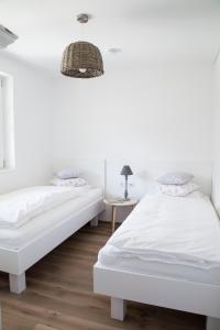 ビザウにあるediths Wohnenの白いベッドルーム(ベッド2台、ランプ付)