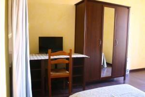 Habitación con escritorio, ordenador y armario. en Albergo Vecchio Pavone en Borgaro Torinese