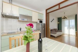 a kitchen and a table with a vase with a flower at Apartment Anic in Bol