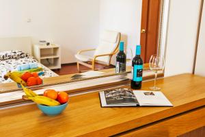 a table with a mirror and a bottle of wine and fruit at La Casa Di Bury Apartments 1 in Saint Petersburg