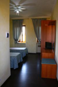una camera d'albergo con due letti e una televisione di Albergo Vecchio Pavone a Borgaro Torinese