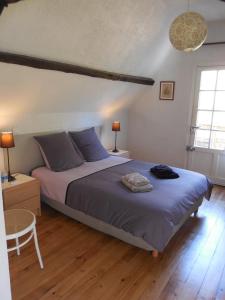 a bedroom with a bed and a table and two lamps at Le Clos des Archers in Laveyssière