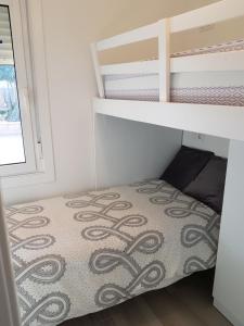 um pequeno quarto com um beliche e uma colcha em Casita en TUY /TOMIÑO em Tui