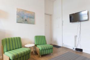 ベルリンにあるStylish & Cosy Apartment in Berlin, WiFiのリビングルーム(椅子2脚、テレビ付)