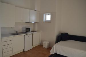 a small kitchen with a bed and a microwave at Aldeamento Turístico de Palmela in Cajados