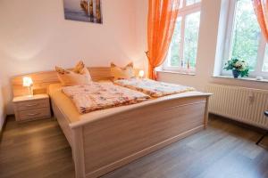 ein Schlafzimmer mit einem großen Bett mit zwei Fenstern in der Unterkunft Villa Malve Wohnung 05 in Bansin