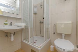 Un baño con ducha, inodoro y lavabo. en Apartments Denis, en Supetar 24 fotos más