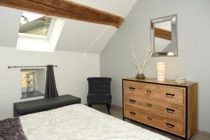 sypialnia z łóżkiem, komodą i krzesłem w obiekcie Gite le murger w mieście Meursault