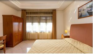 um quarto com uma cama e uma janela com cortinas em Ranch Palace Hotel em Nápoles