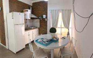 a kitchen with a white table and a white refrigerator at Terraza del Sol Apart in San Juan