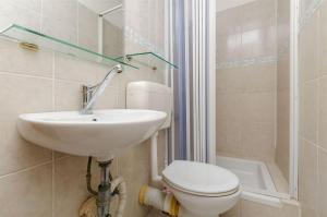 a bathroom with a sink and a toilet and a shower at Apartment Barba in Rogač +12 photos