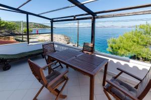 a table and chairs on a balcony with a view of the water at House Barbarina in Rogač