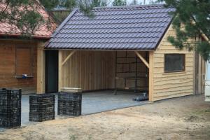 a shed with a metal roof on top of it at Winnica Dębogóra in Woldenberg Neumark