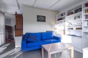 um sofá azul numa sala de estar com uma mesa em Ulivi a Milano em Milão