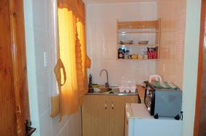 a small kitchen with a sink and a microwave at Acropolis Hostal in La Serena