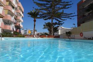 - une piscine au milieu d'un immeuble avec des palmiers dans l'établissement Valparaiso Top Floor, à Playa del Ingles