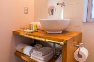 La salle de bains est pourvue d'un comptoir avec un lavabo et des serviettes. dans l'établissement Augusta Hotel, à Valparaíso