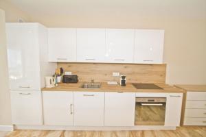 尼斯的住宿－PROMENADE HOLIDAY - COSY SEA FRONT STUDIO，厨房配有白色橱柜和水槽