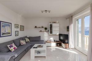 a living room with a couch and a tv at Apartments Mare in Postira