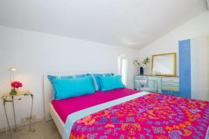 a bedroom with a large bed with a colorful bedspread at Apartments Vesela in Podaca