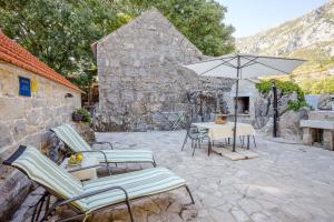 een patio met een tafel en stoelen en een parasol bij House Gordana in Gata