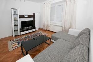 een woonkamer met een bank en een tv bij Downtown 3 Bedroom Apartment in Sarajevo