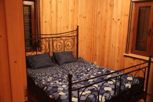 Woldenberg NeumarkにあるWinnica Dębogóraの木製の壁の客室の黒いベッド1台