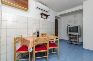 une salle à manger avec une table et une télévision dans l'établissement Apartment Boris, à Gornja Brela