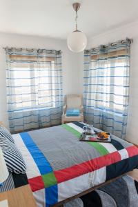 a bedroom with a large bed with a colorful blanket at Fabulous Beach House on the Atlantic in Baleal