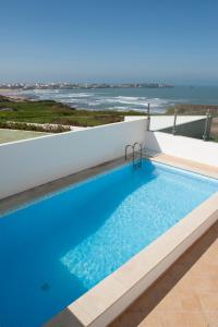 a swimming pool with a view of the ocean at Fabulous Beach House on the Atlantic in Baleal