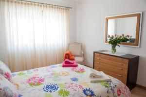 a bedroom with a bed with a dresser and a mirror at Fabulous Beach House on the Atlantic in Baleal