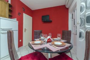 a dining room with a black table and red walls at Apartments Ita in Postira