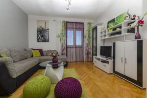 een woonkamer met een bank en een tafel bij Apartments Ita in Postira