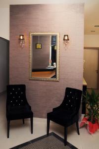 2 sillas en una sala de espera con espejo en Hotel Helen Park, en Canakkale