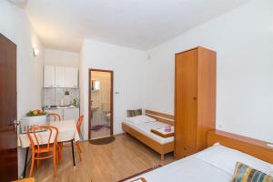 Habitación pequeña con cama y cocina en Apartments Ante, en Igrane