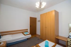 a bedroom with a bed and a wooden cabinet at Apartments Ante in Igrane +18 photos
