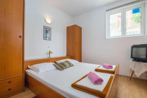 a bedroom with a bed with two pink pillows on it at Apartments Ante in Igrane