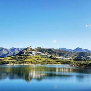 una gran masa de agua con montañas en el fondo en El Rinconcito, en Zahara de la Sierra