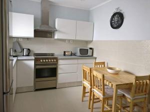 a kitchen with a table and a stove and a microwave at Long Beach Apartamento AL in Praia da Vitória