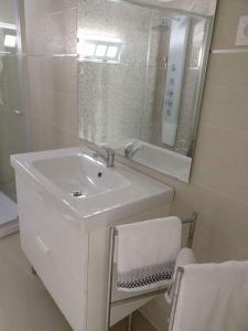 a white bathroom with a sink and a mirror at Long Beach Apartamento AL in Praia da Vitória +30 photos