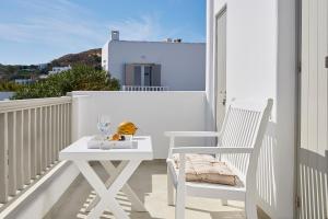 a white table and a white chair on a balcony at Pagona Studios in Pollonia