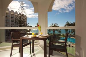 a dining room with a table and chairs on a balcony at Ona Marinas de Nerja Spa Resort in Nerja