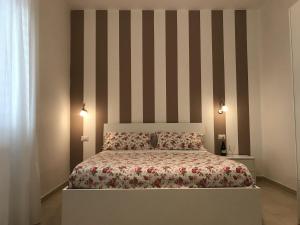 ヴィーコ・エクエンセにあるcasa Francyのベッドルーム1室(ストライプの壁のベッド1台付)