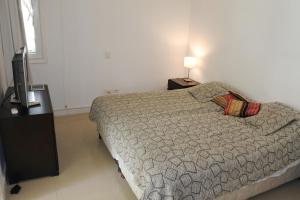 - une chambre avec un lit et une télévision à écran plat dans l'établissement Green Park en Punta del Este, à Punta del Este