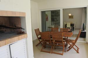 una sala da pranzo con tavolo, sedie e camino di Green Park en Punta del Este a Punta del Este