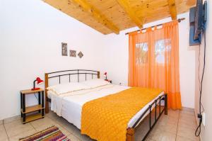 a bedroom with a bed and a tv and a window at House Mislav in Velike Kuknjare